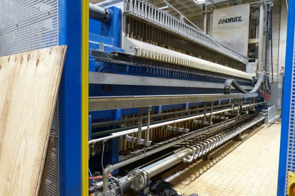 Membraanfilterpers laat slibkoek in een trechter vallen